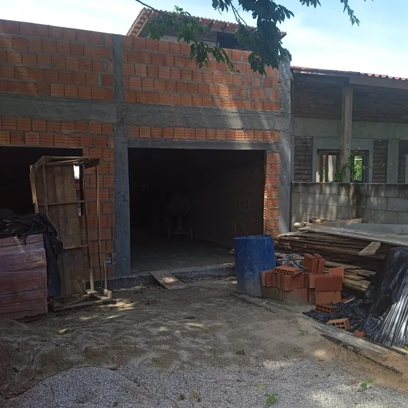 Estrutura de concreto com vigas aparentes e vedação em blocos cerâmicos, em obra de dois pavimentos.